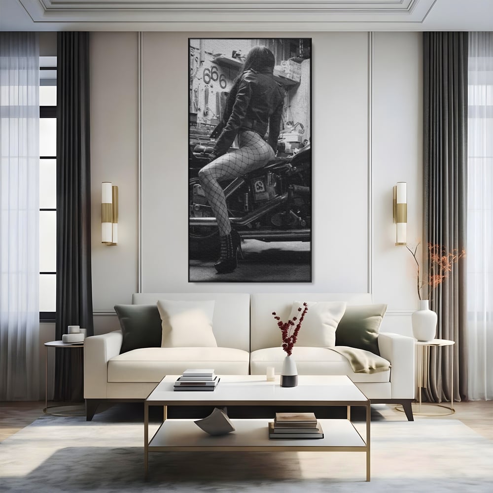 Tablou canvas cu tablou canvas cu femeie pe motocicleta, in rama de aluminiu negru, pe perete intr-un living